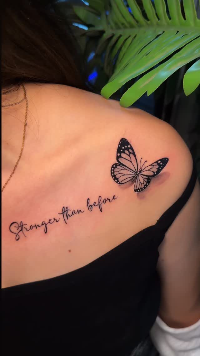 A black ink butterfly tattoo and cursive text on a person's collarbone.