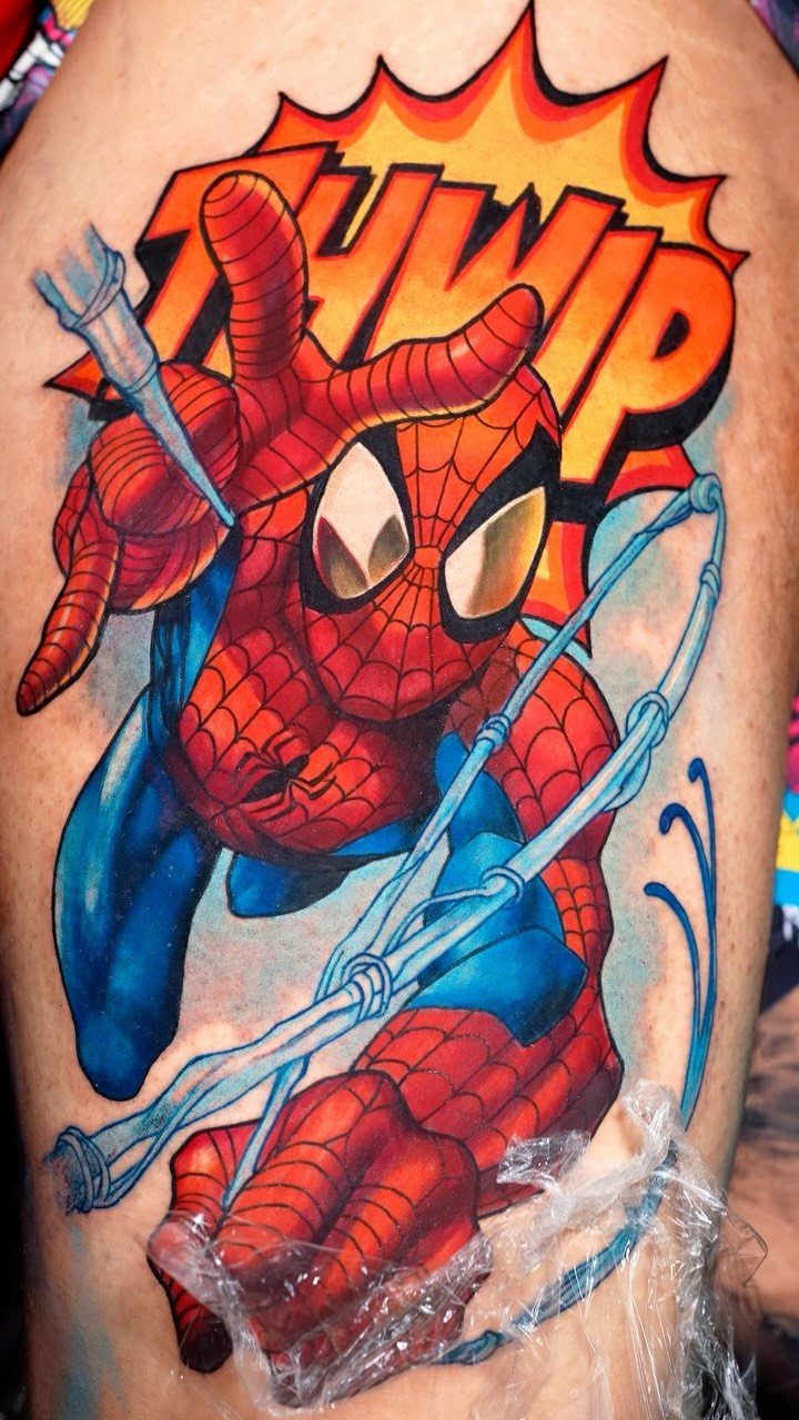 8 Color Tattoo Ideas for Men: Comic, Dragon & Watercolor 1 Spider-Man comic book style tattoo with a red and blue color scheme on skin.