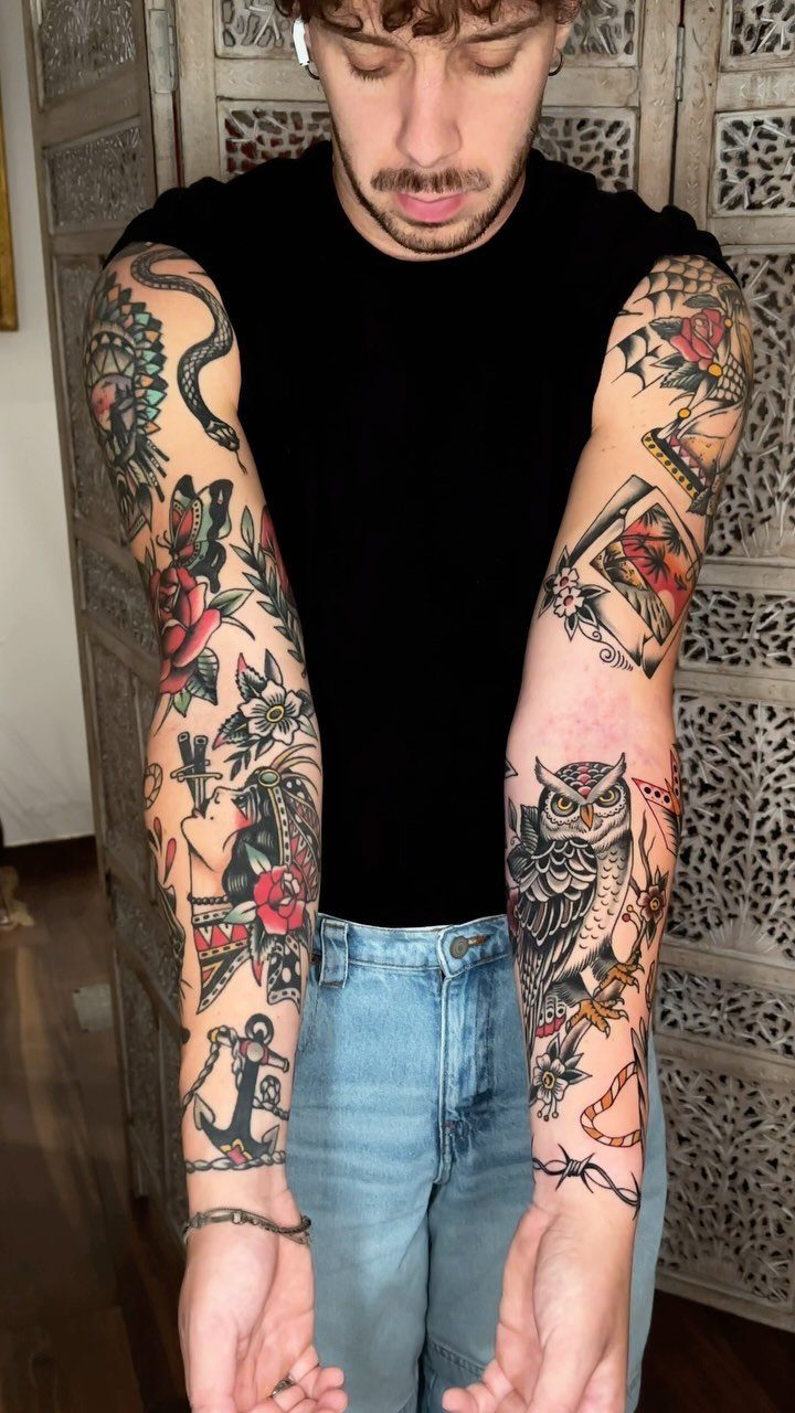 A man displaying colorful neo-traditional tattoos covering both of his arms.