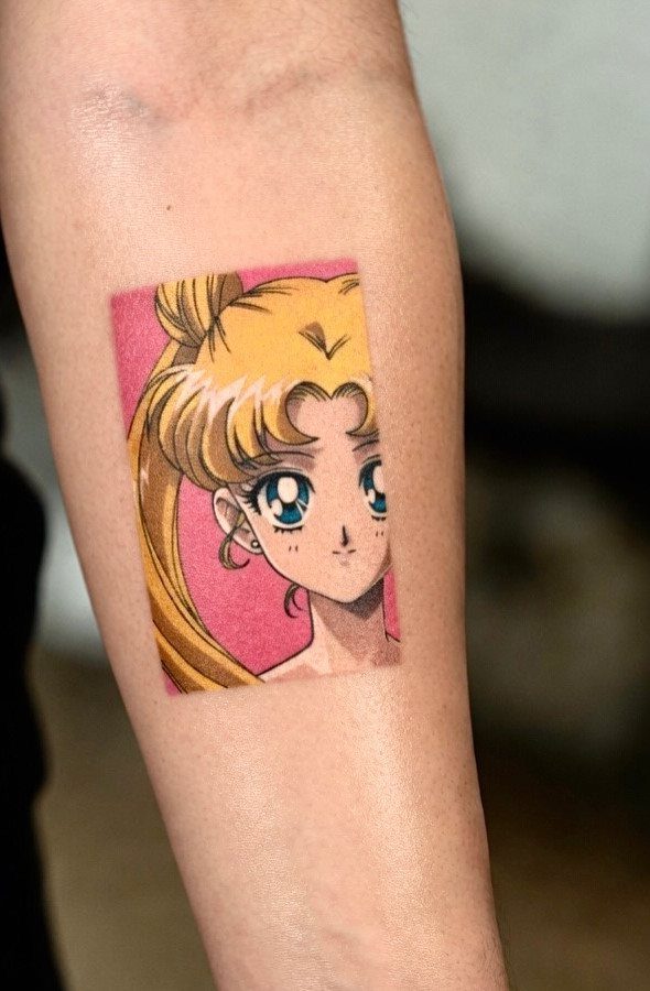 An anime character tattoo with blonde hair and blue eyes on a person's arm.