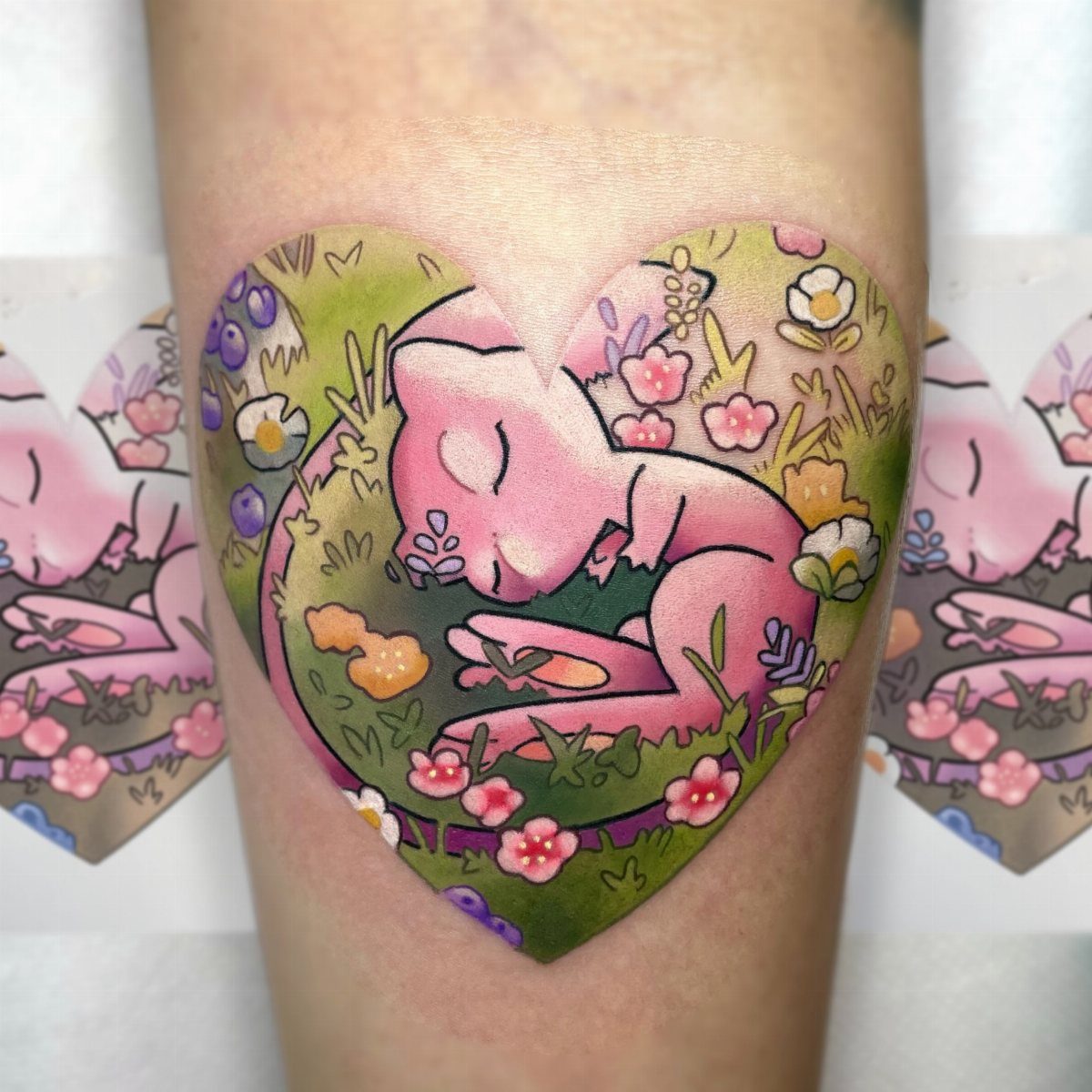 A pink kitten sleeping in a flowery meadow inside a heart-shaped tattoo on skin.