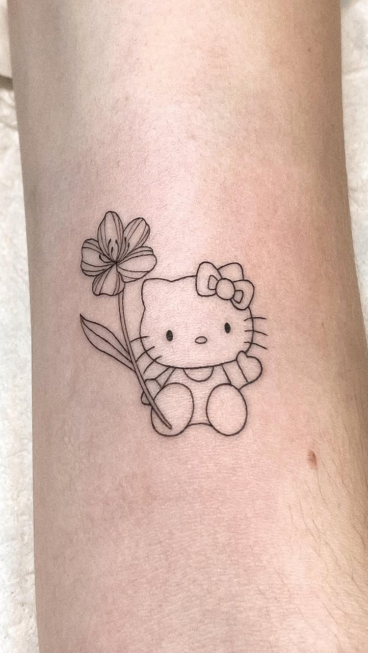 Hello Kitty character tattoo holding a large flower on a person's skin.