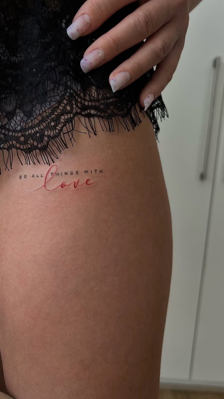 7 Leg Tattoo Ideas for Women: Geometric, Floral, Fine Line & More 4 A fine line red script tattoo on a person's thigh reading do all things with love.