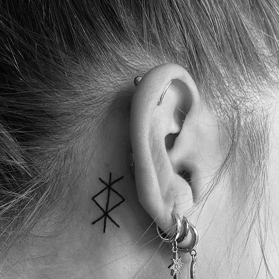 Rune Tattoo Ideas: 18 Symbols and Placements Worth Studying 1 A small black bind rune tattoo on a person's neck behind their ear.