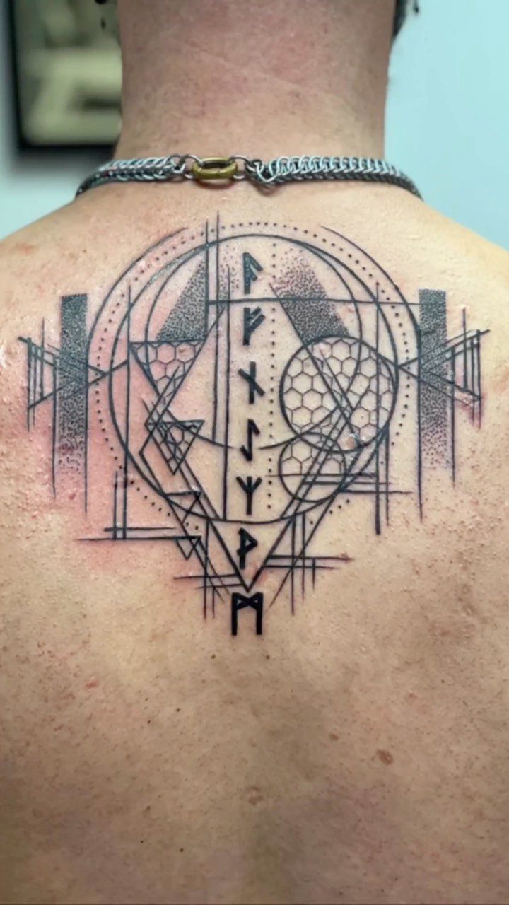 Rune Tattoo Ideas: 18 Symbols and Placements Worth Studying 6 Geometric rune tattoo with circles and triangles on a person's upper back.