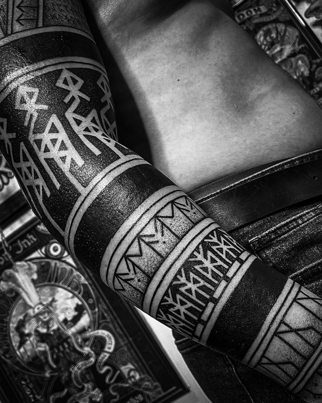 Rune Tattoo Ideas: 18 Symbols and Placements Worth Studying 16 A person's arm covered in a detailed black and white runic sleeve tattoo.
