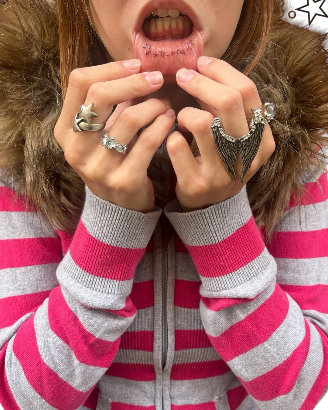 15 Small Tattoo Placement Ideas for Every Style 15 A person pulls down their lower lip to show small star tattoos on the inner lip.