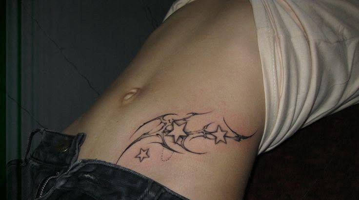 A black ink star and line tattoo placed on a person's lower abdomen and v-line area.