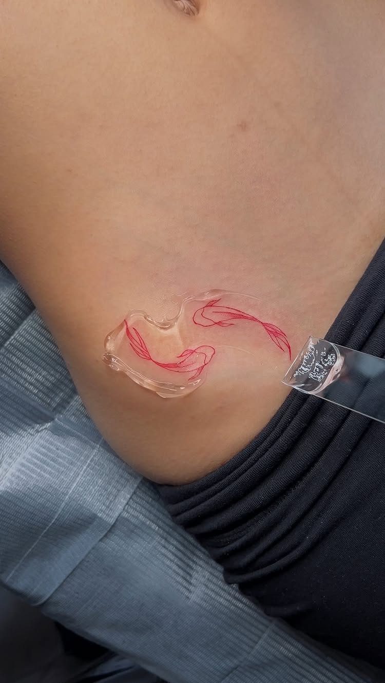 Red ink stencil being applied to a person's hip area for a fine line tattoo.