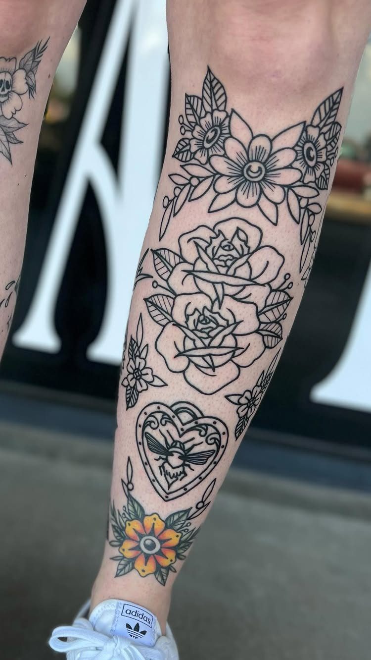 14 Tattoo Style Outline Ideas for Your Next Appointment 3 A person's lower leg decorated with various black ink floral and heart outline tattoos.