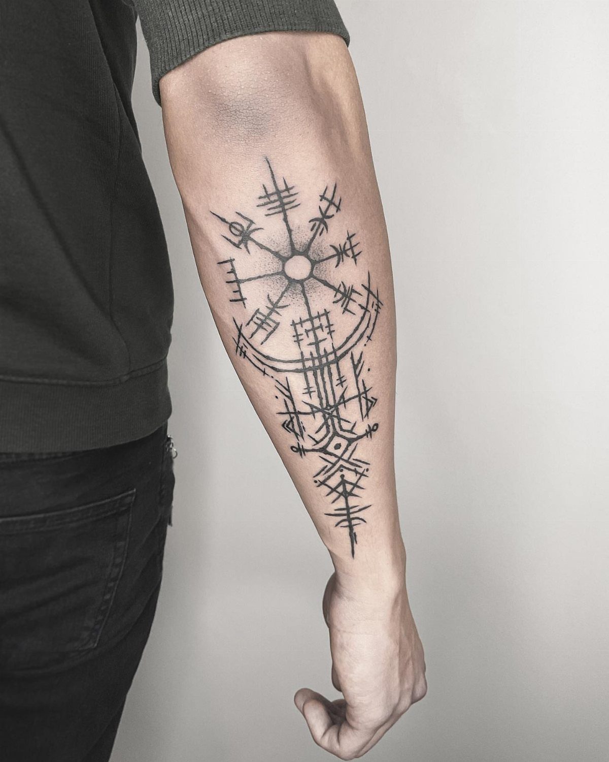A black ink Viking rune tattoo on a person's forearm against a plain background.